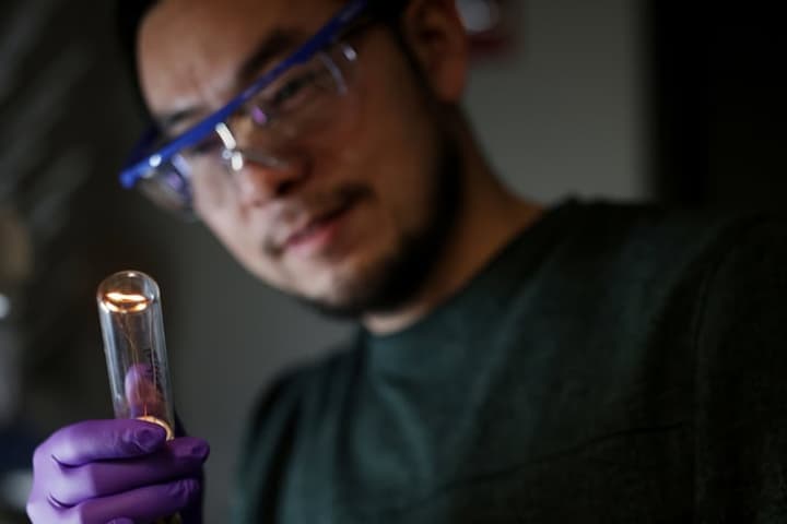 Researcher Jun Lu, examining the twisted filament of an Edison bulb