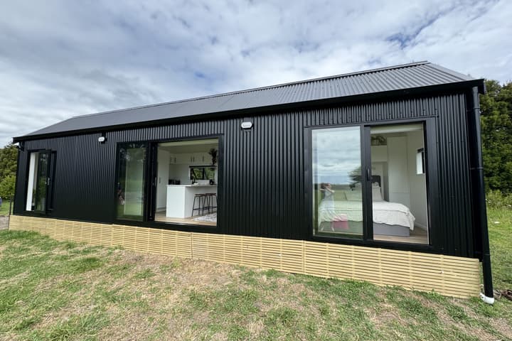 The Long Black (with loft) is a light-filled tiny house that includes two bedrooms and space for a home office